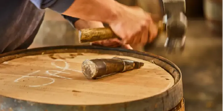 Hammering a whisky barrel