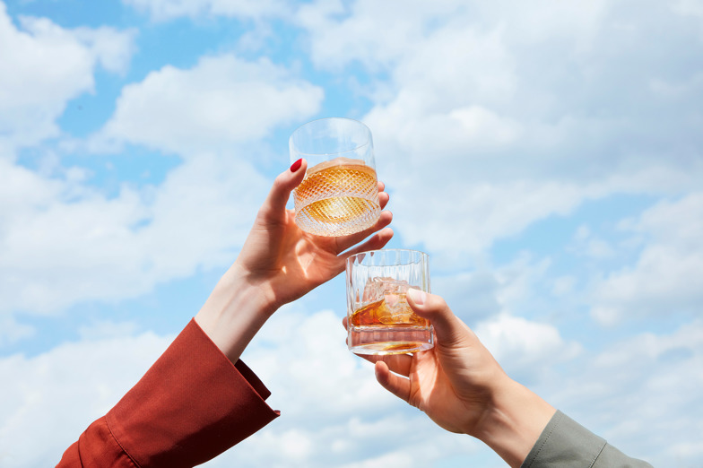Two hands clinking glasses together